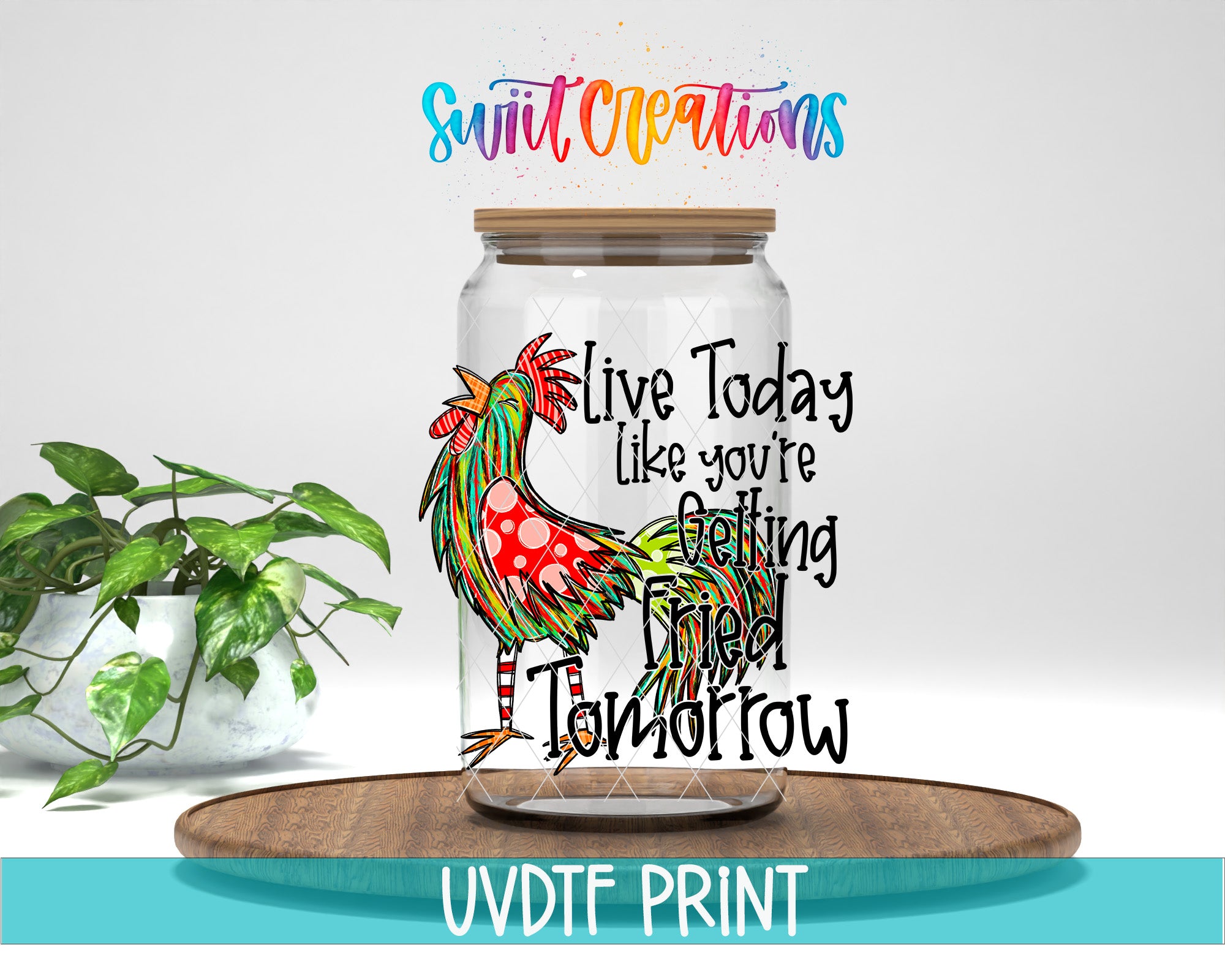 A glass jar with a colorful rooster design on it, placed on a wooden surface. The jar has a lid and a label with text on it. There is also a potted plant in the background.