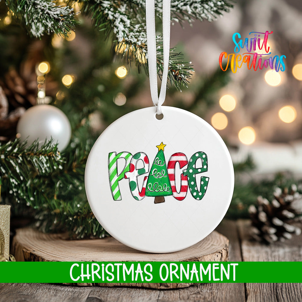 A white Christmas ornament with the word "Peace" written on it, hanging from a tree branch.