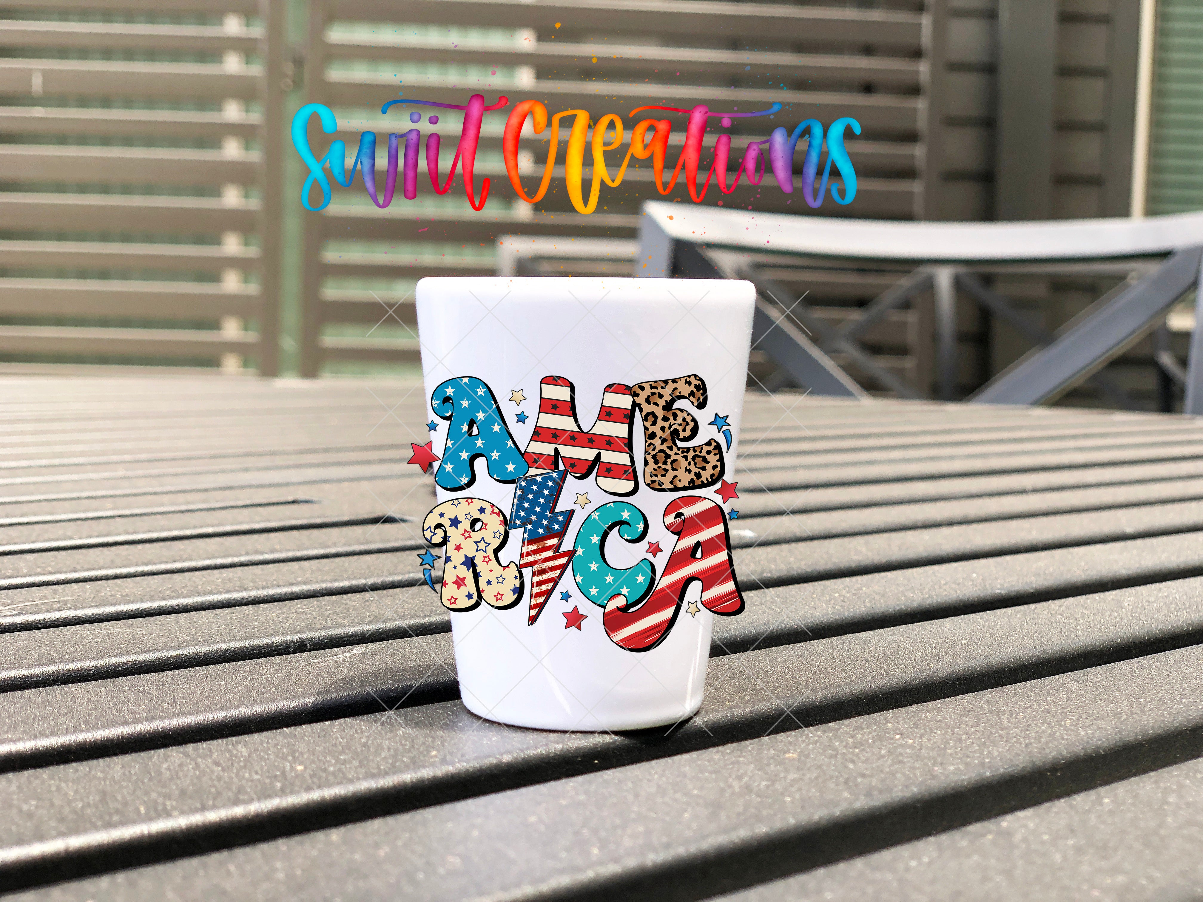A white mug with the word "AMERICA" printed on it, sitting on a wooden surface.
