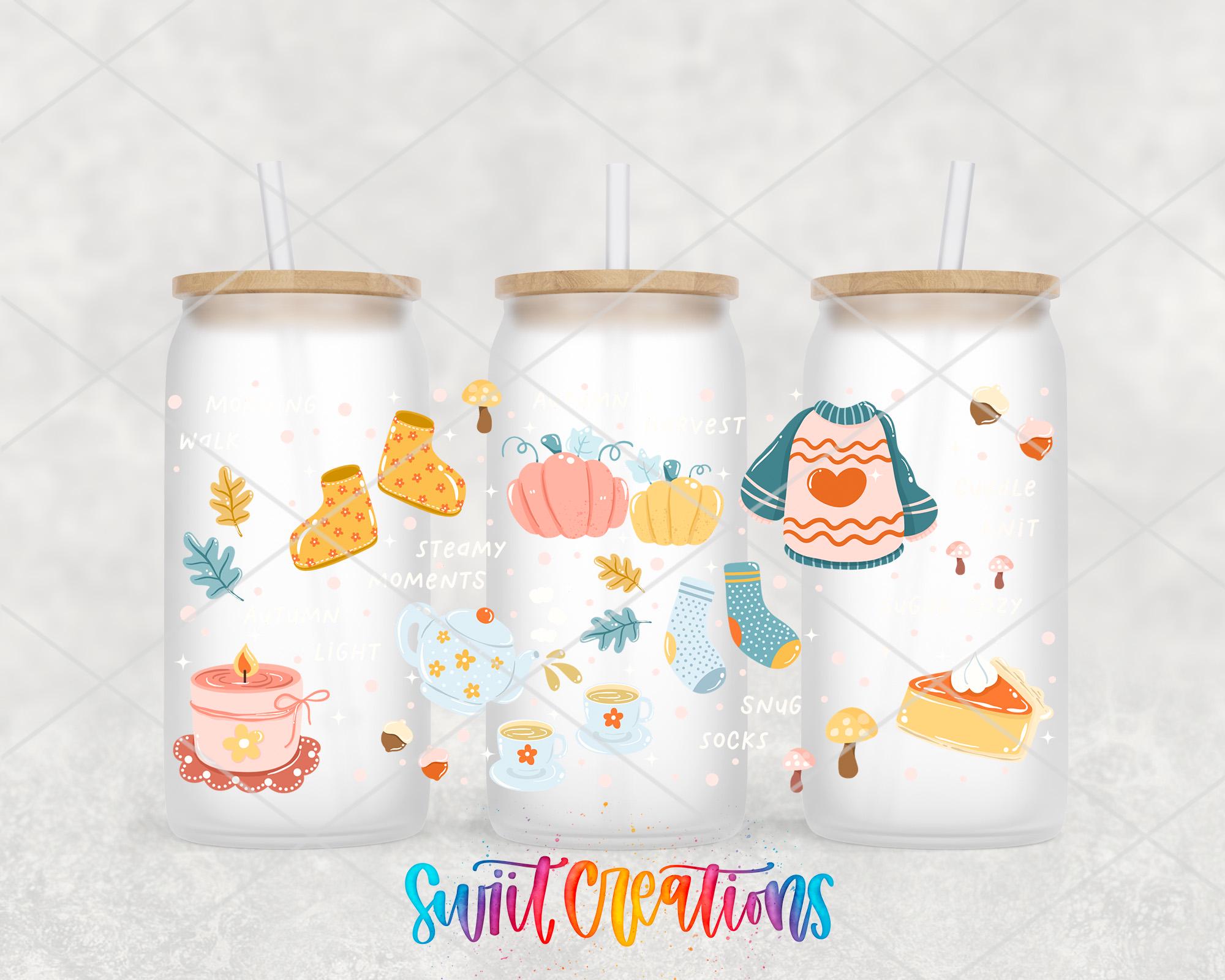 three glass tumblers with colorful illustrations of fall-themed items, such as pumpkins, mittens, and a sweater, along with straws.