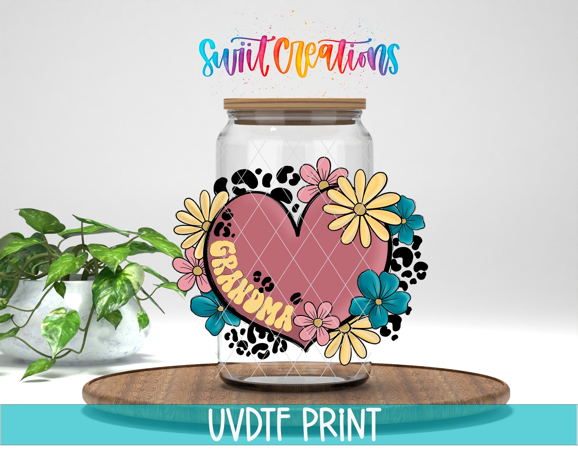 A glass jar with a heart-shaped design and colorful flowers, along with the text "Grandma" written on it, placed on a wooden surface.