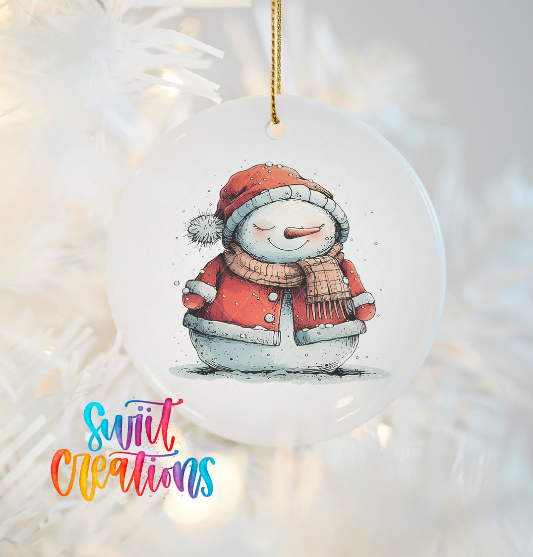 A snowman ornament with a red scarf and hat, sitting on a snowy surface, is hanging on a Christmas tree.