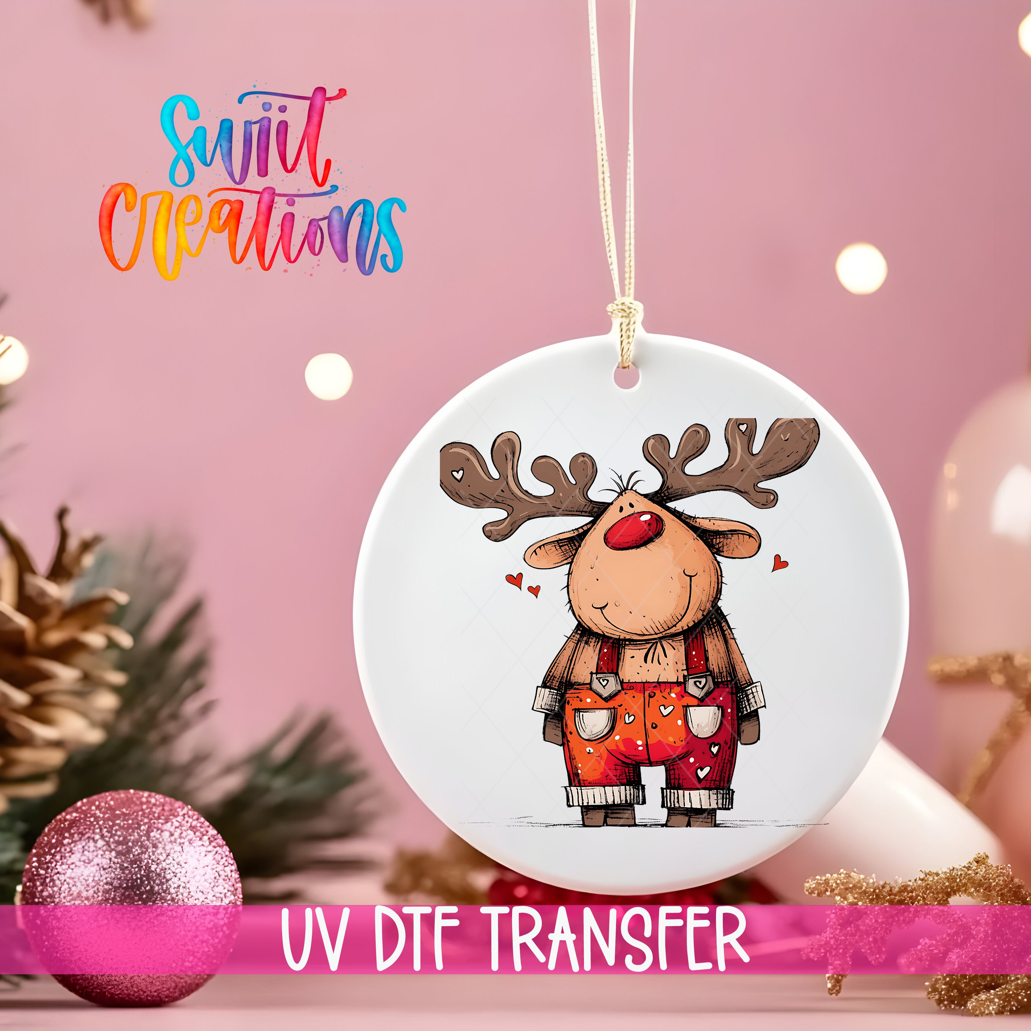 A white ornament with a cartoon reindeer design hangs against a pink background, with a pink glitter ball and pine branches in the foreground.