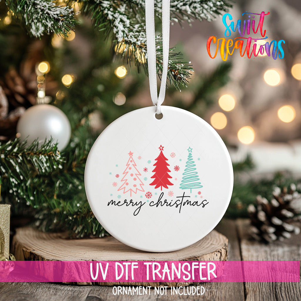 A white ceramic ornament with a Christmas tree design and the text "Merry Christmas" hangs on a Christmas tree.