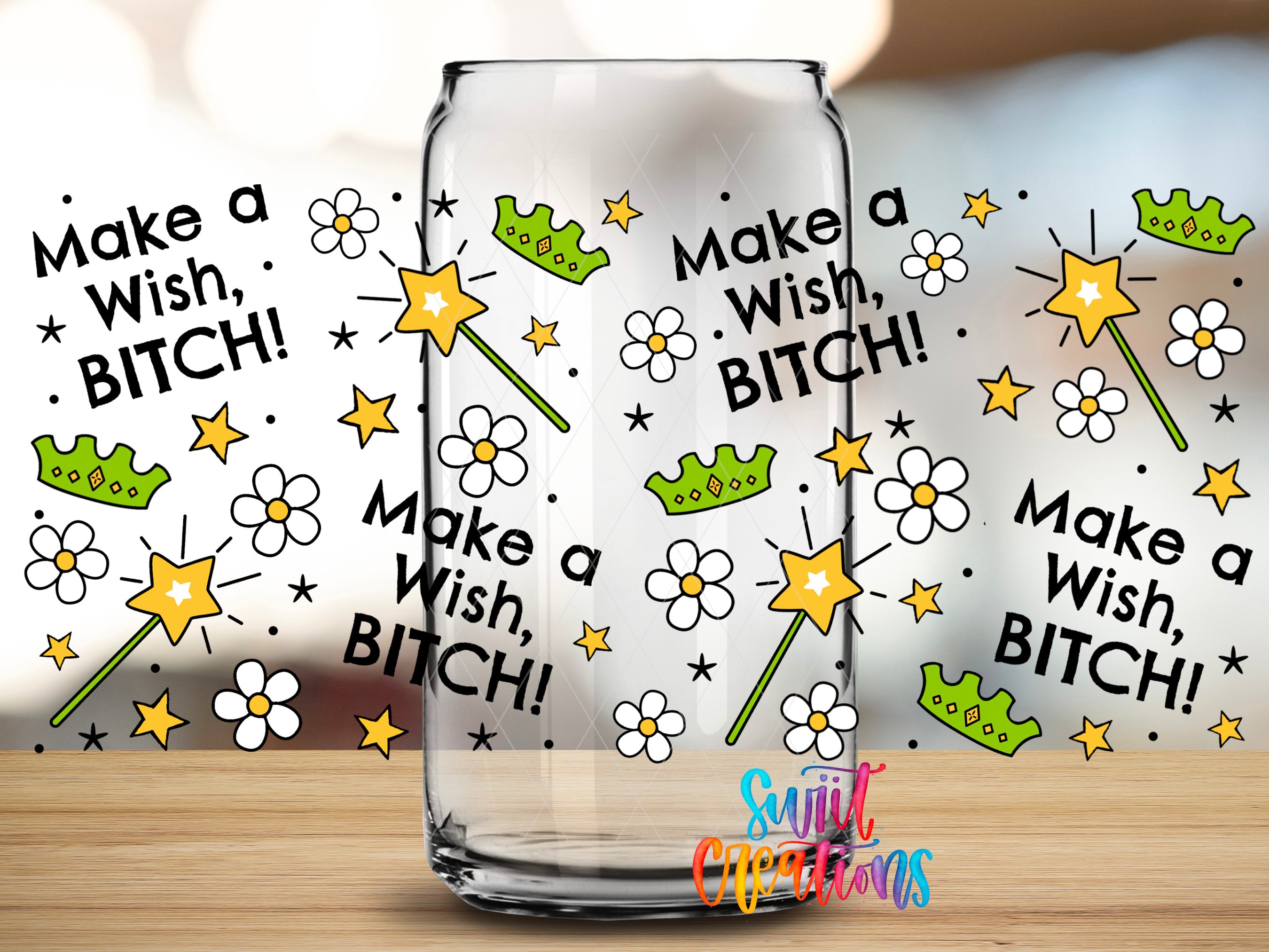a clear glass mug with a whimsical and playful design on it. The mug is surrounded by various illustrations, including stars, flowers, crowns, and the text "Make a Wish, Bitch!" The overall design is colorful and creative, with the text and illustrations complementing each other.
