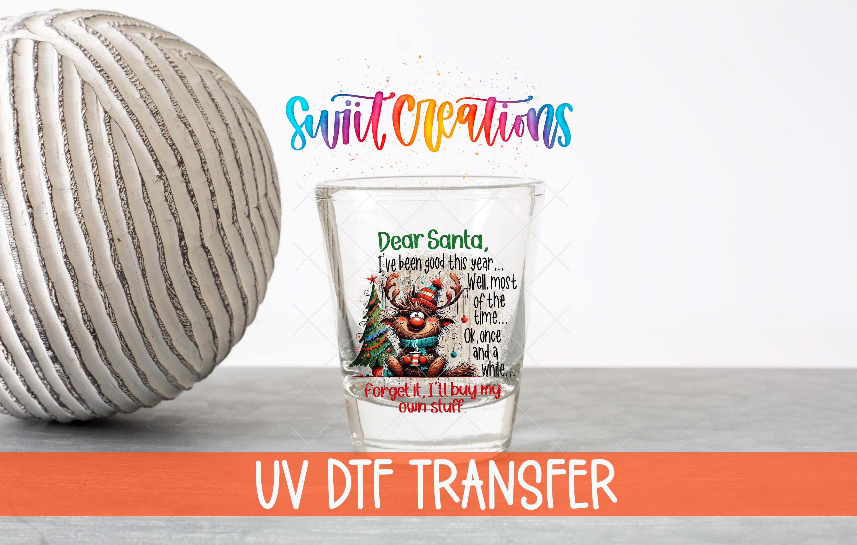 a glass with a Christmas-themed design, including a reindeer and text that appears to be a personalized message from Santa Claus. The glass is placed on a gray surface, and there is a white ball in the background. The image also includes text that says "UV DFT TRANSFER" and "Forget it, I'll buy you a stocking stuffer."