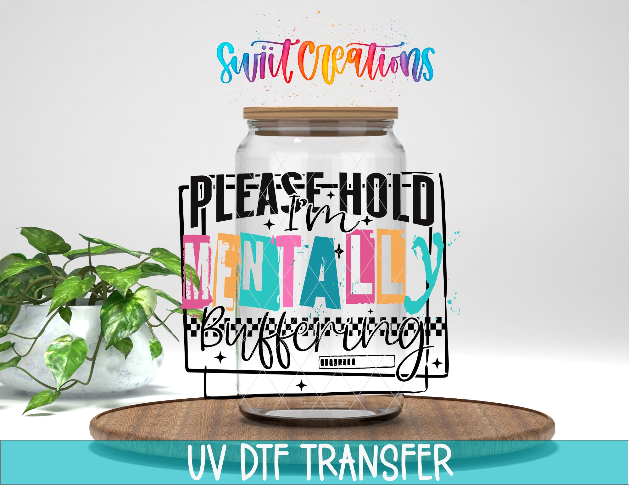 a large glass jar with a wooden lid, surrounded by a plant and a wooden tray. The jar has a colorful, artistic design with text that reads "Please hold mentally buffering".