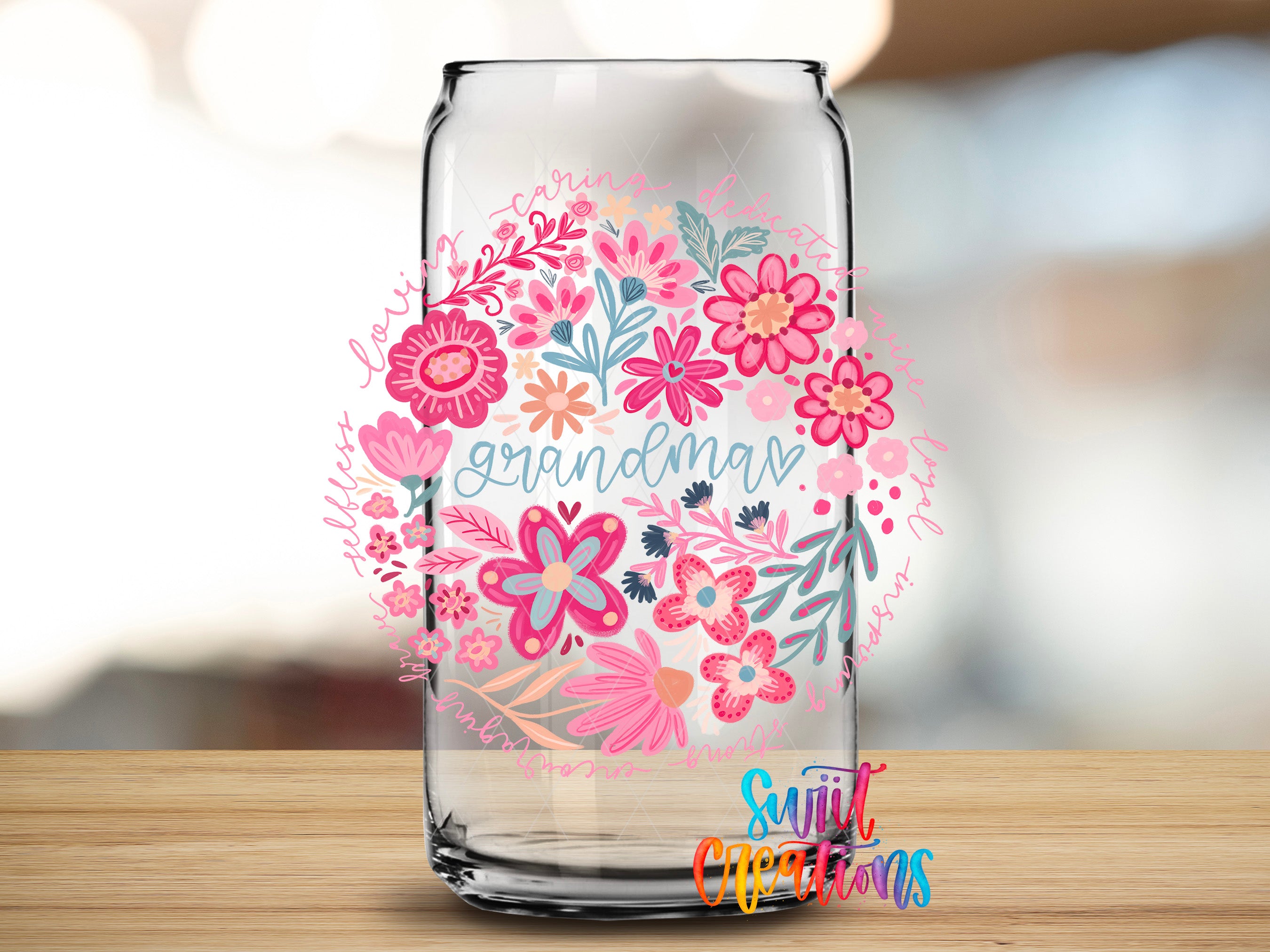 A glass jar with a floral design and the word "Grandma" written on it, placed on a wooden surface.