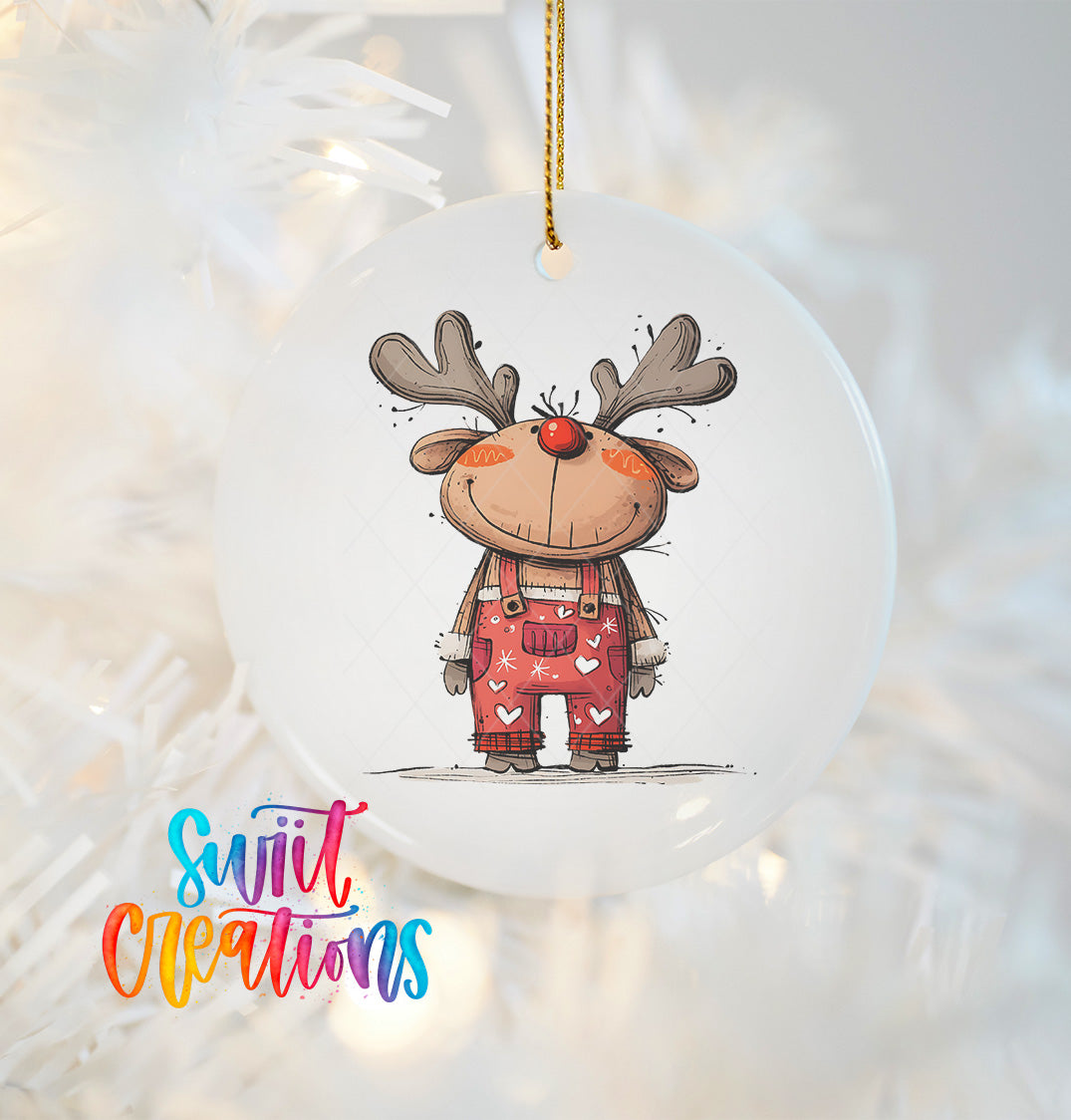 A white ornament featuring a cartoon reindeer wearing overalls and a red nose, hanging on a Christmas tree.