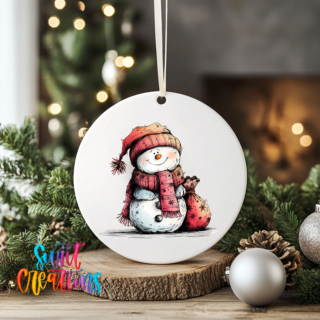 A white ceramic ornament featuring a snowman wearing a red scarf and hat, holding a bag, is displayed on a wooden surface with Christmas decorations in the background.