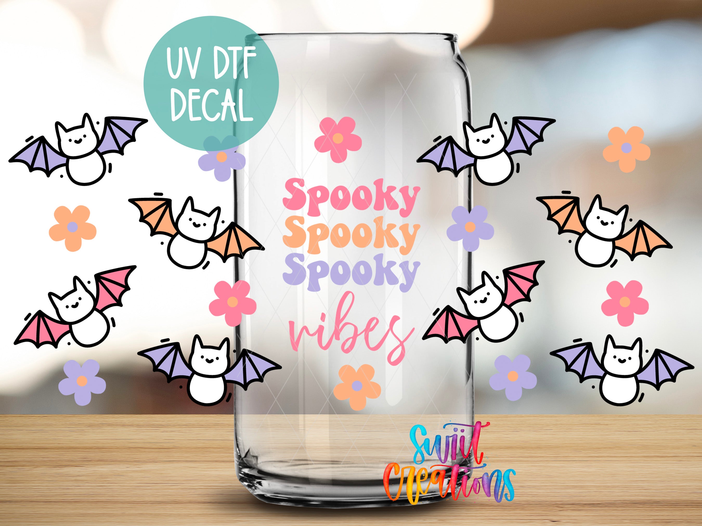 a clear glass with a UV decal of bats and flowers, along with the text "Spooky Spooky Vibes" printed on it.