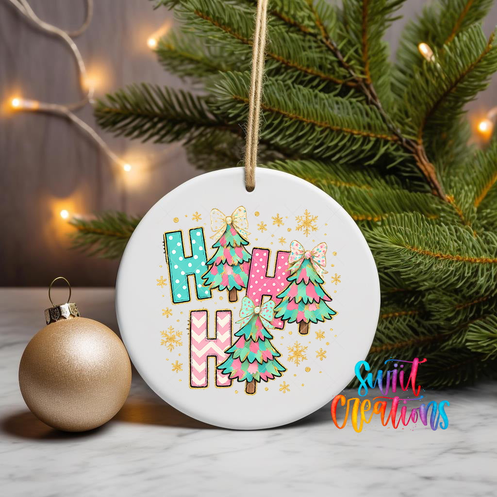 A white ceramic ornament with a colorful design featuring Christmas trees and snowflakes, hanging on a string. The ornament has the text "Haha" written on it.