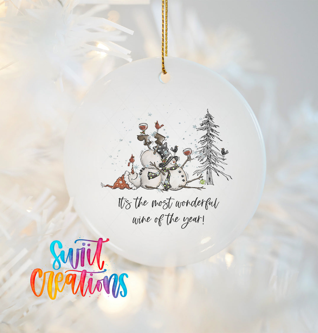 A white ceramic ornament with a snowman and other winter-themed elements, along with a text that reads "It's the most wonderful wine of the year!"
