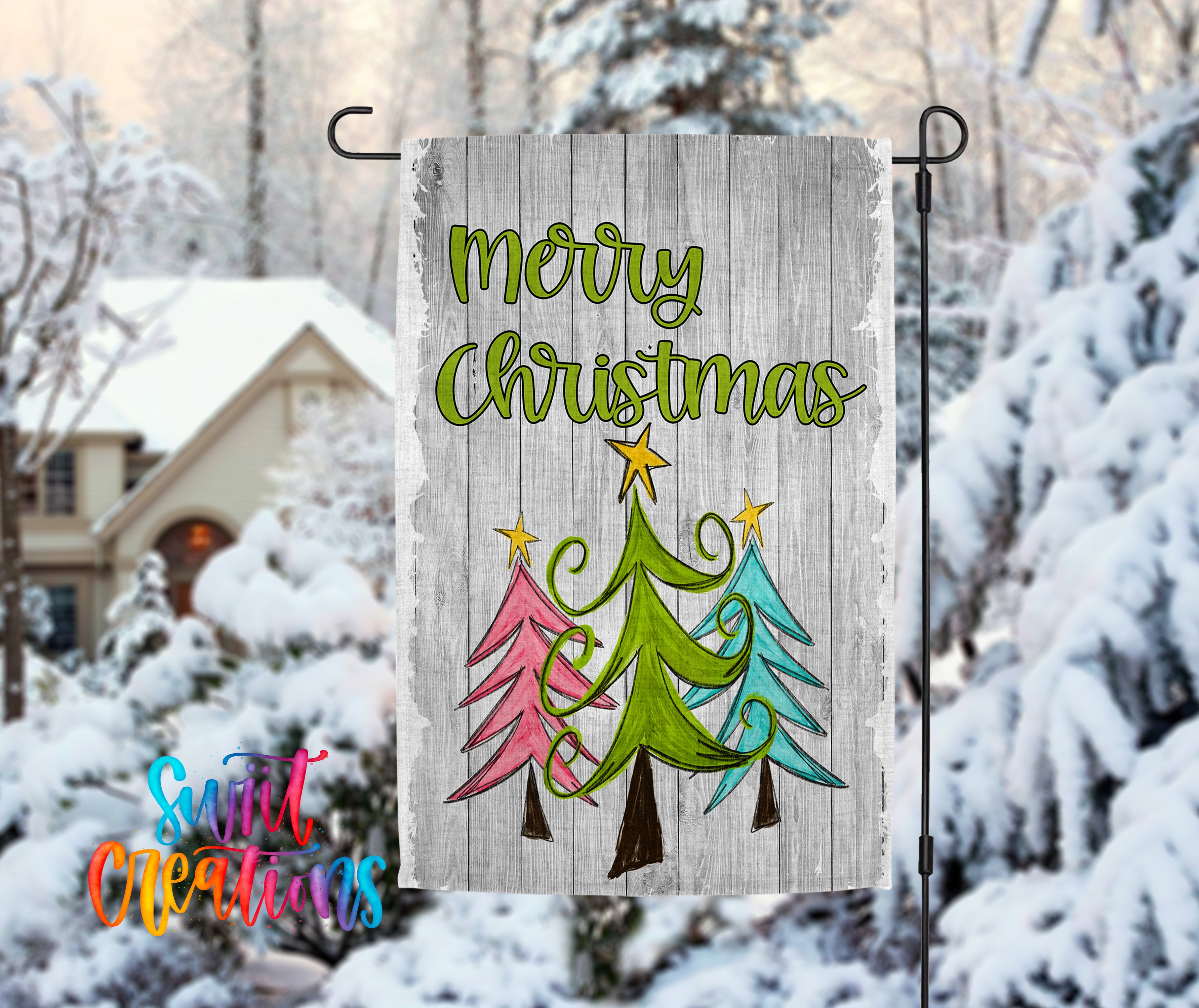 A wooden Christmas tree decoration with the text "Merry Christmas" displayed on it, set against a snowy background with a house and trees in the distance.