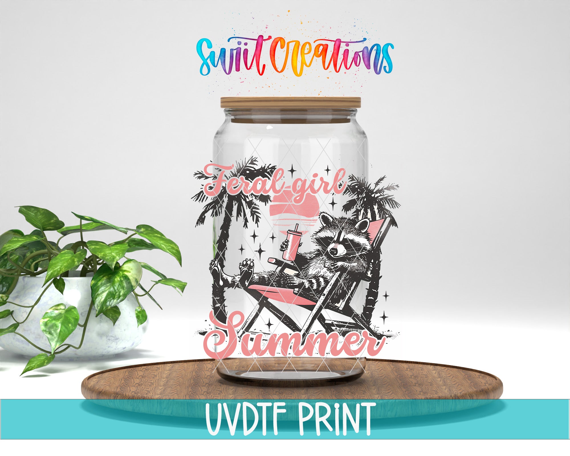 A glass jar with a raccoon sitting in a beach chair, surrounded by palm trees, and the text "Feral Girl Scummer" printed on it. The jar is placed on a wooden tray, and there is a potted plant in the background.