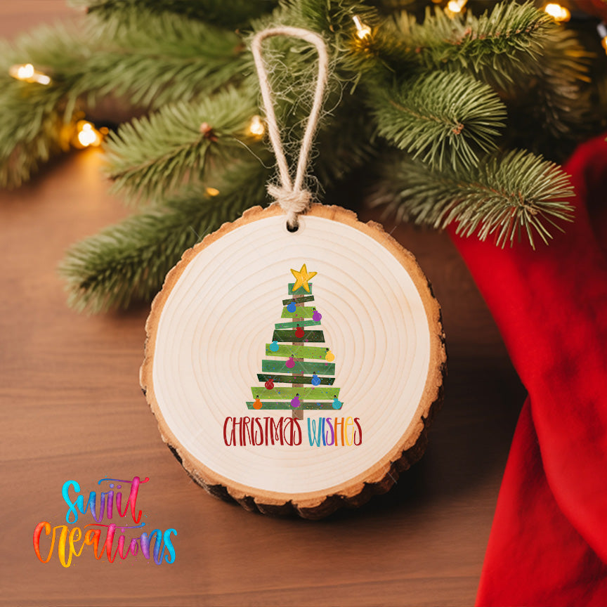 A wooden ornament with a Christmas tree design hangs on a tree branch, surrounded by twinkling lights.