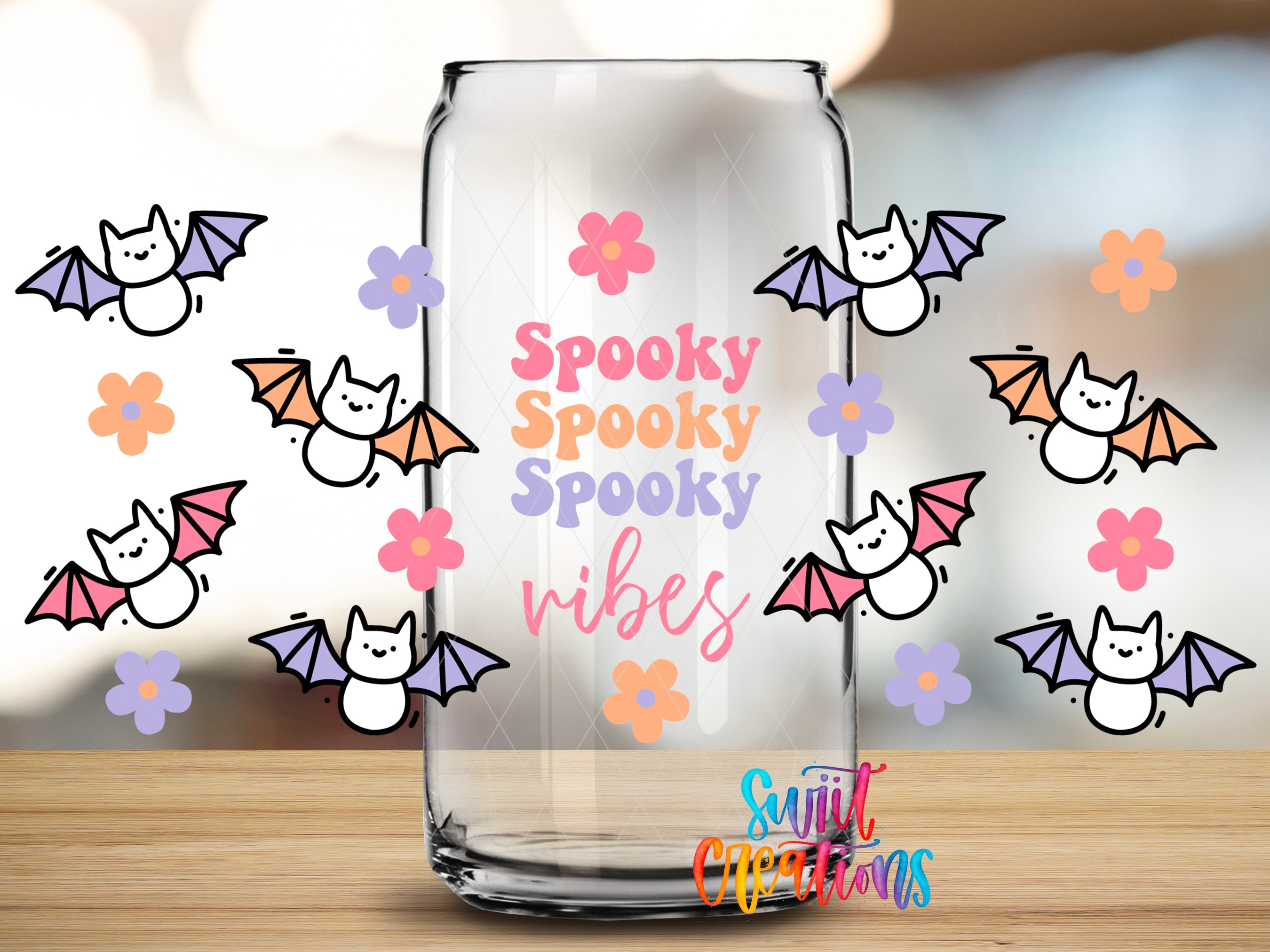 a clear glass can with a playful design of bats and flowers surrounding it.