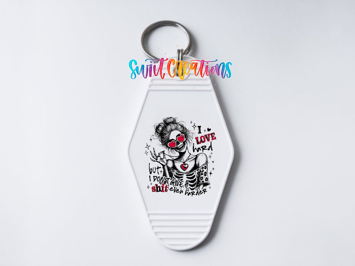 Close-up of the I Love Hard UV DTF transfer on a white motel keychain