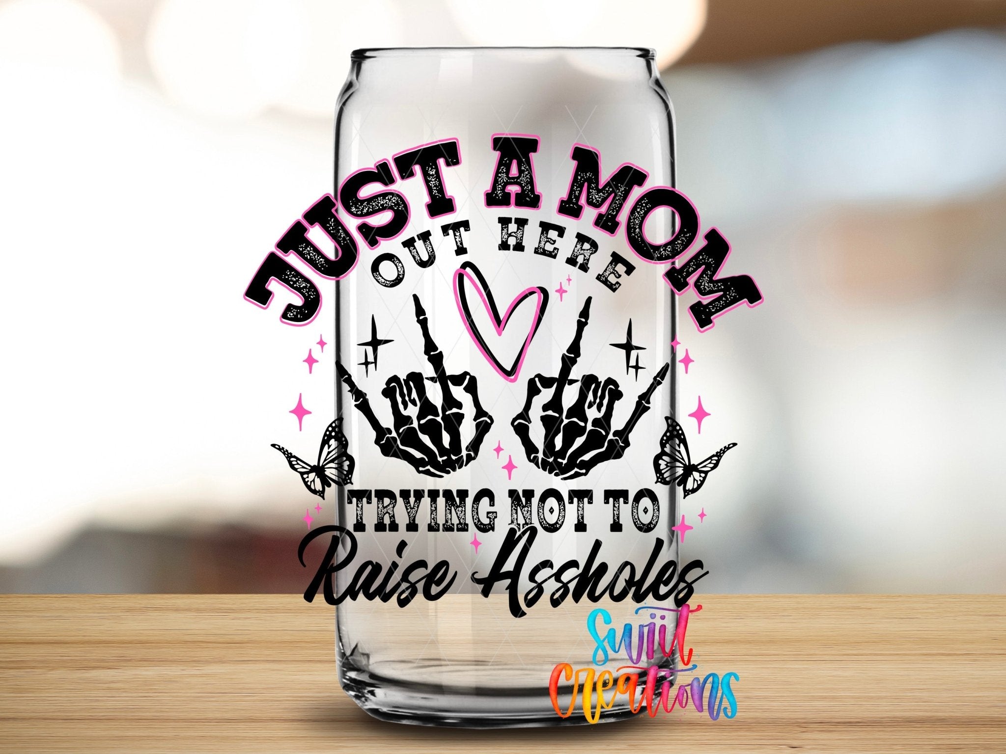 Just a Mom Trying Not To Raise Assholes UV DTF transfer applied to a clear glass can from Swiit Creations
