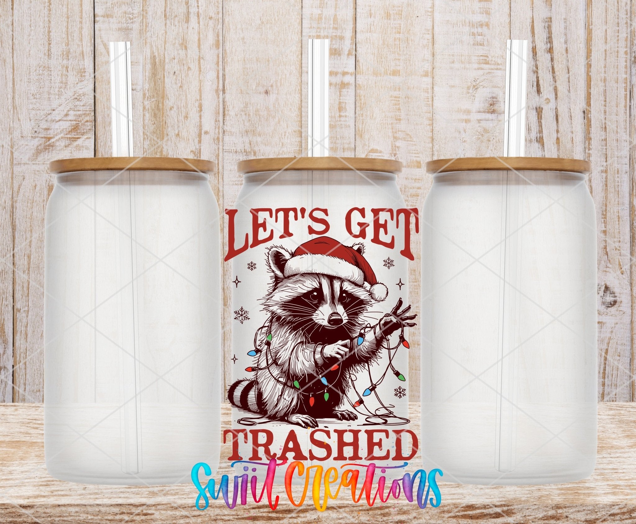 Swiit Creations UV DTF Let’s Get Trashed Christmas Raccoon transfer shown on a clear glass can set