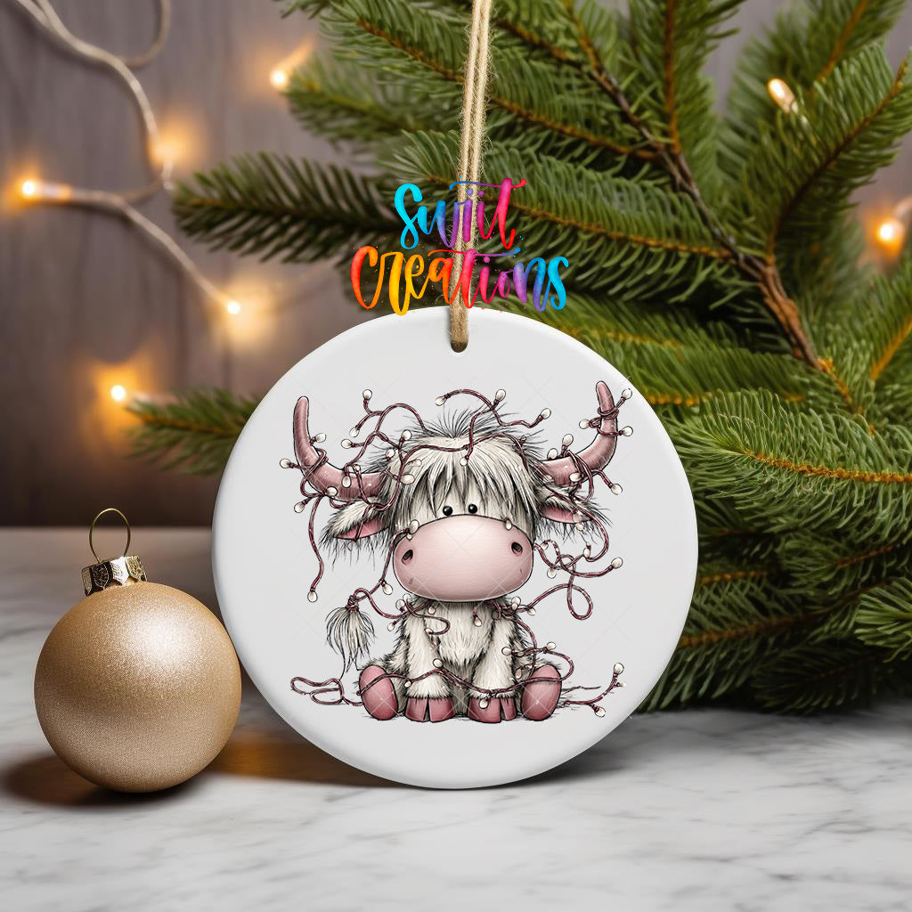 Cute pink Highland cow ornament design wrapped in holiday lights