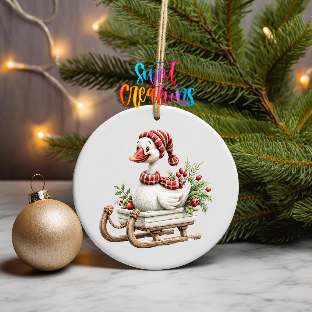 Christmas goose ornament UV DTF transfer riding wooden sleigh with greenery and red berries, mockup view 3