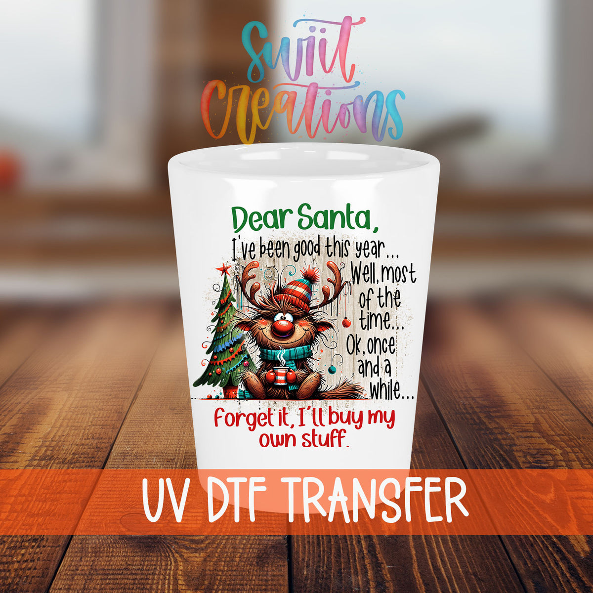 Santa I've Been Good Christmas shot glass transfer on a white shot glass on a wooden table