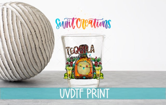 a ball of yarn next to a shot glass