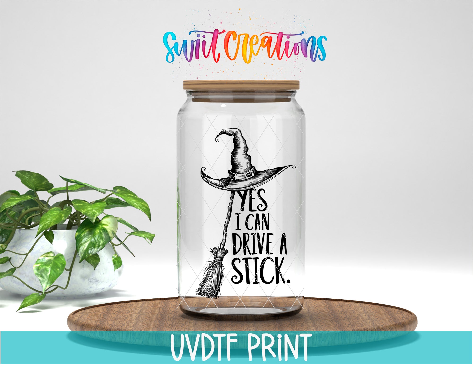 A glass jar with a witch's hat and the text "YES I CAN DRIVE A STICK" printed on it, placed on a wooden surface.