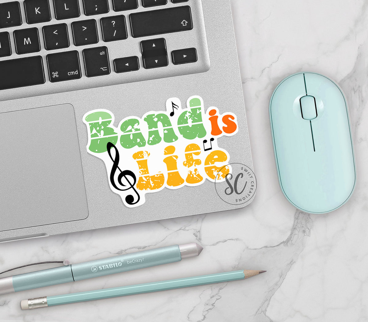 Band Is Life vinyl sticker on a silver laptop next to a mint mouse and pens