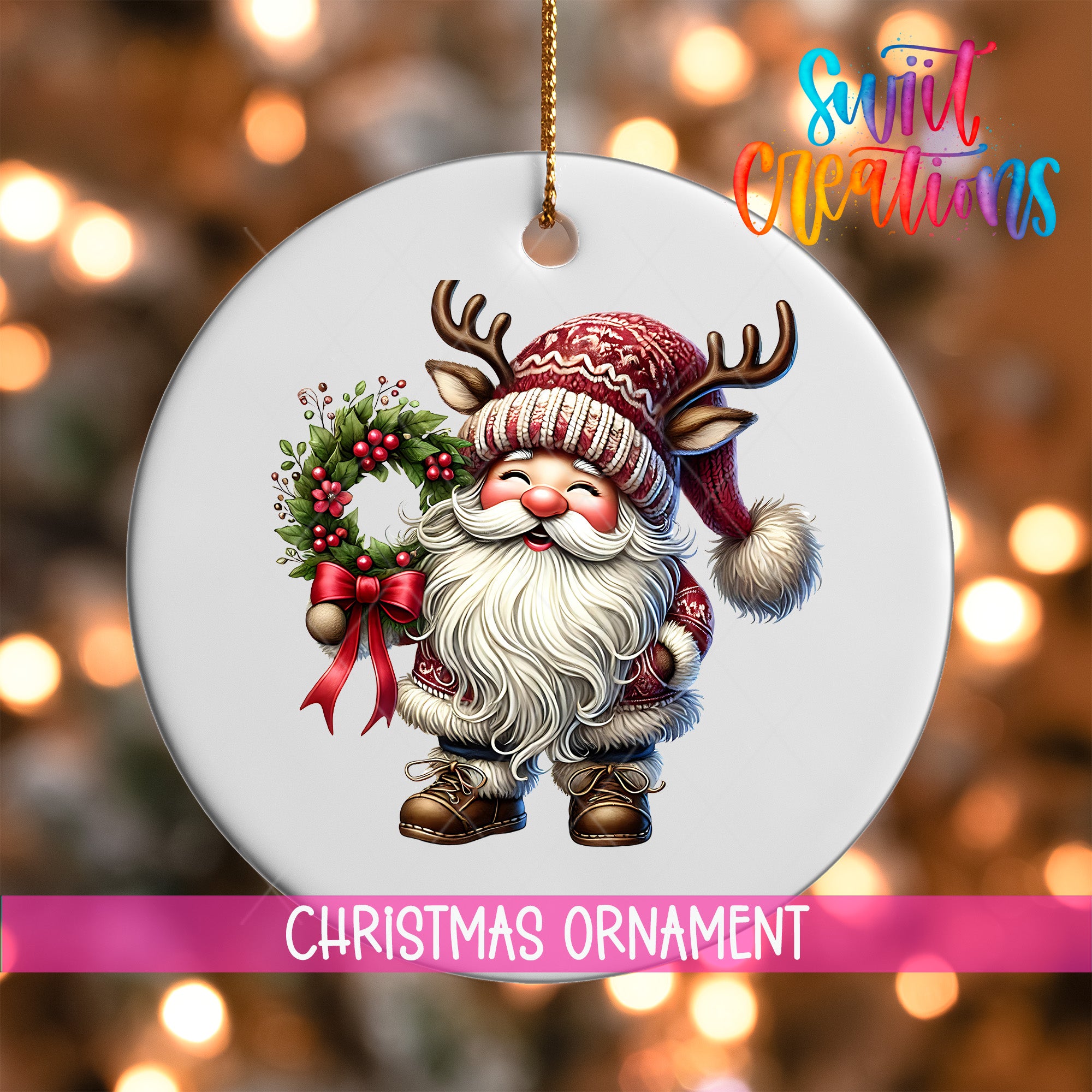 A white Christmas ornament featuring a smiling Santa Claus with antlers and a wreath, set against a blurred background of Christmas lights.
