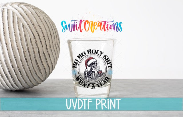 a ball of yarn next to a shot glass