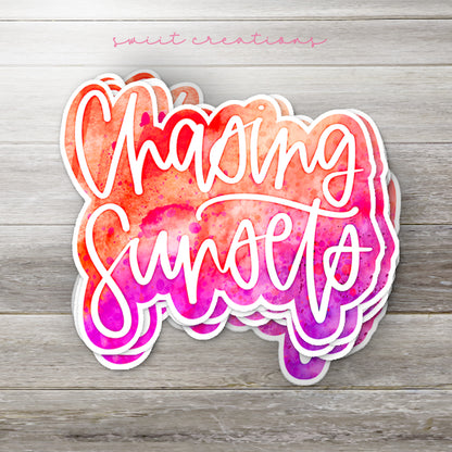 Stack of Chasing Sunsets glossy stickers on a gray wood table