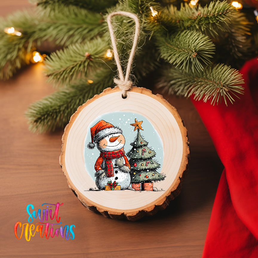 A wooden ornament featuring a snowman and a Christmas tree, with a star on top, hangs on a Christmas tree.