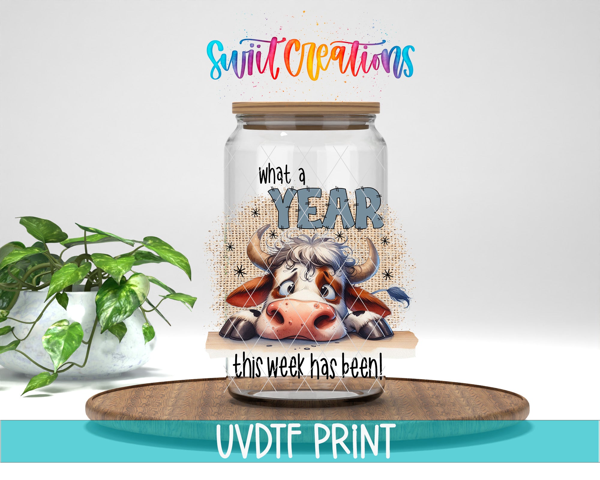 a glass jar with a cartoon cow on it, placed on a wooden surface. The jar has a label that says "What a YEAR this week has been!" and there is a plant in the background.