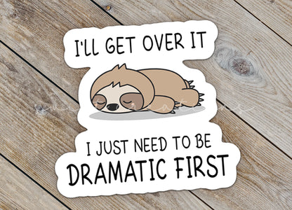 Close-up of the Dramatic Sloth sticker on rustic wood