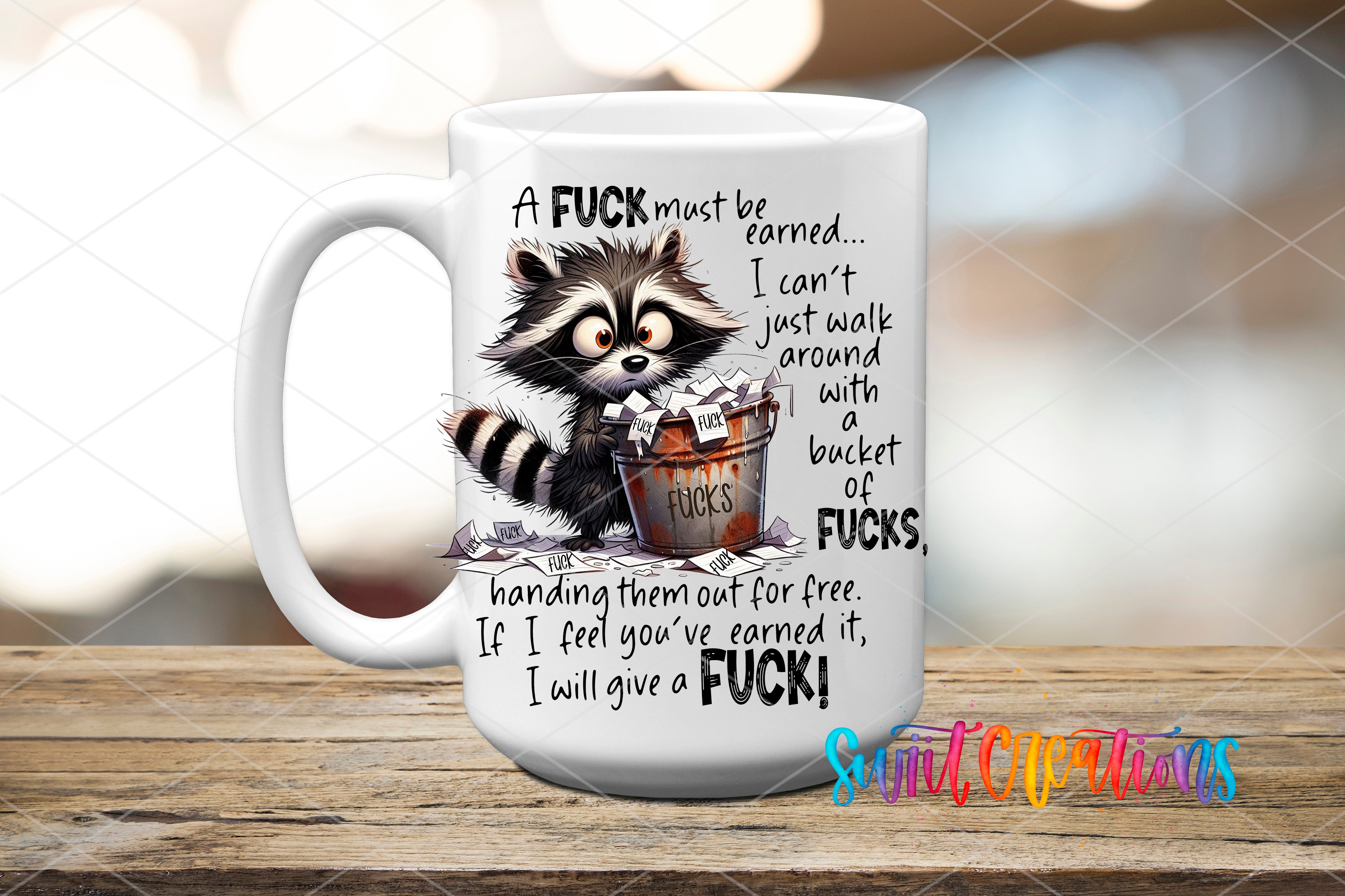 A mug with a raccoon and text on it, sitting on a wooden surface.