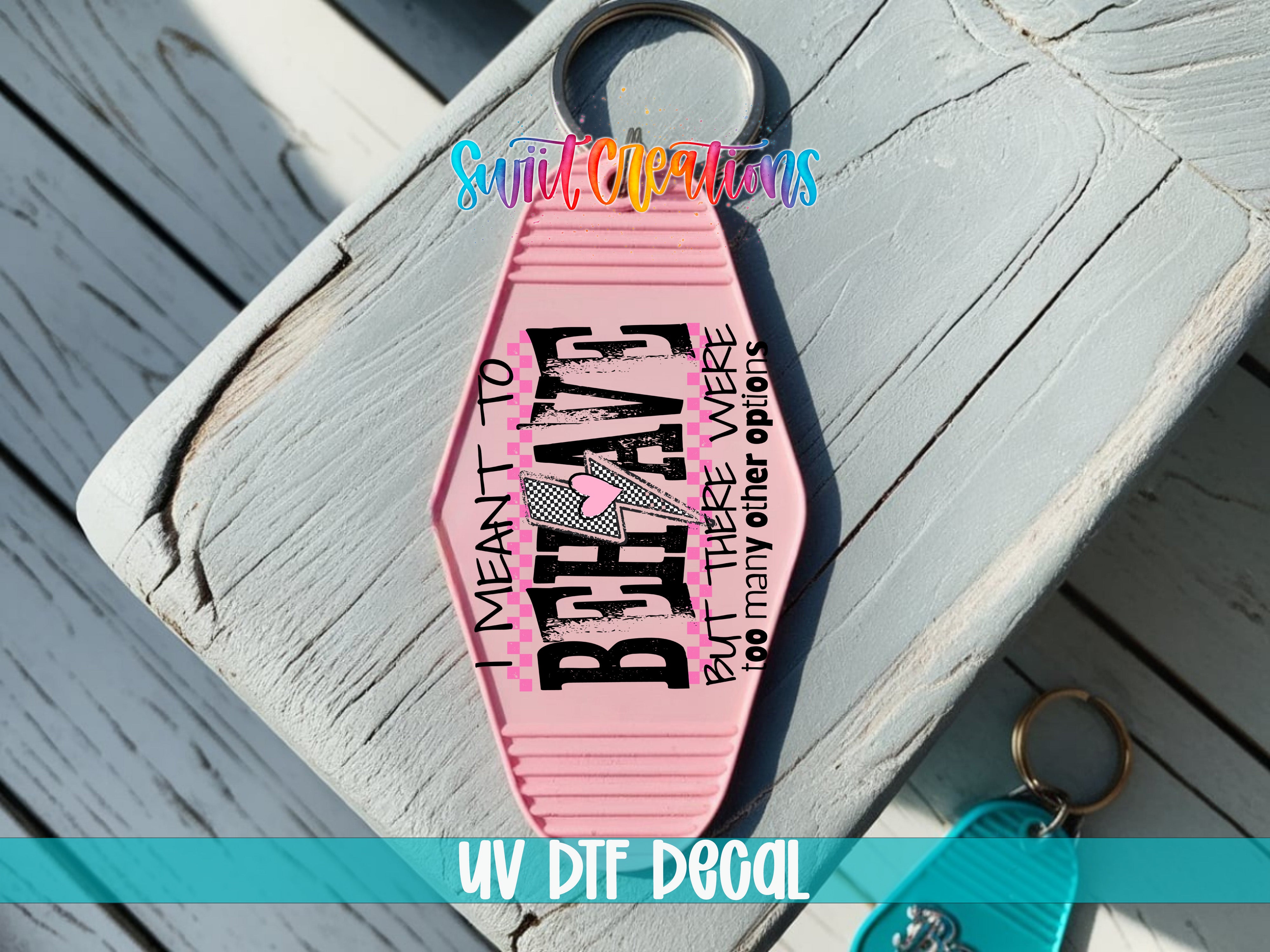 A pink keychain with the text "I MEANT TO BE A LESS THAN 5" printed on it, along with a heart symbol.