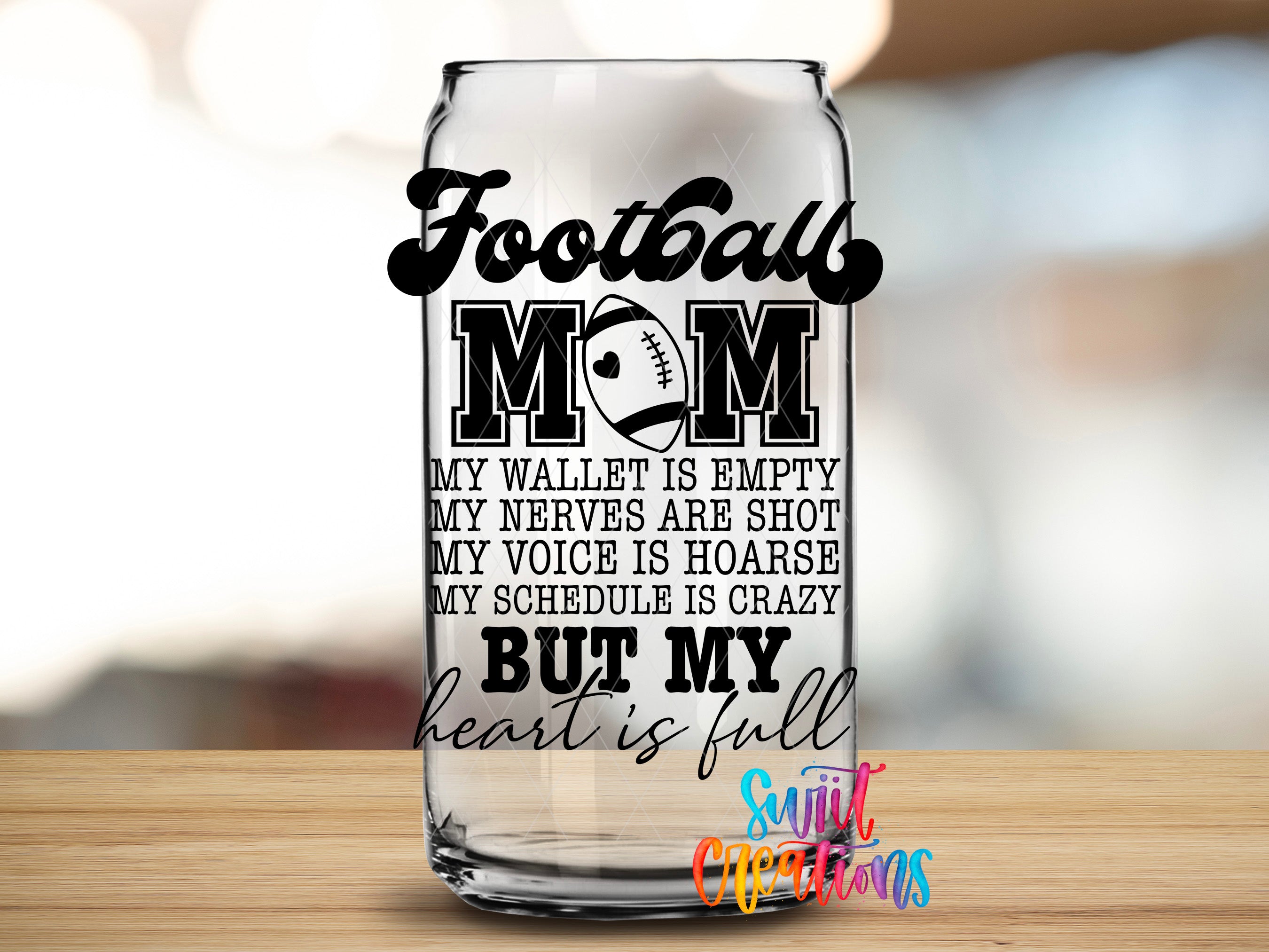 A glass can with a humorous text printed on it, placed on a wooden surface.