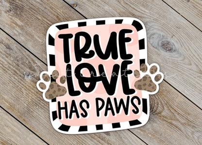 Close-up of the True Love Has Paws sticker on rustic wood