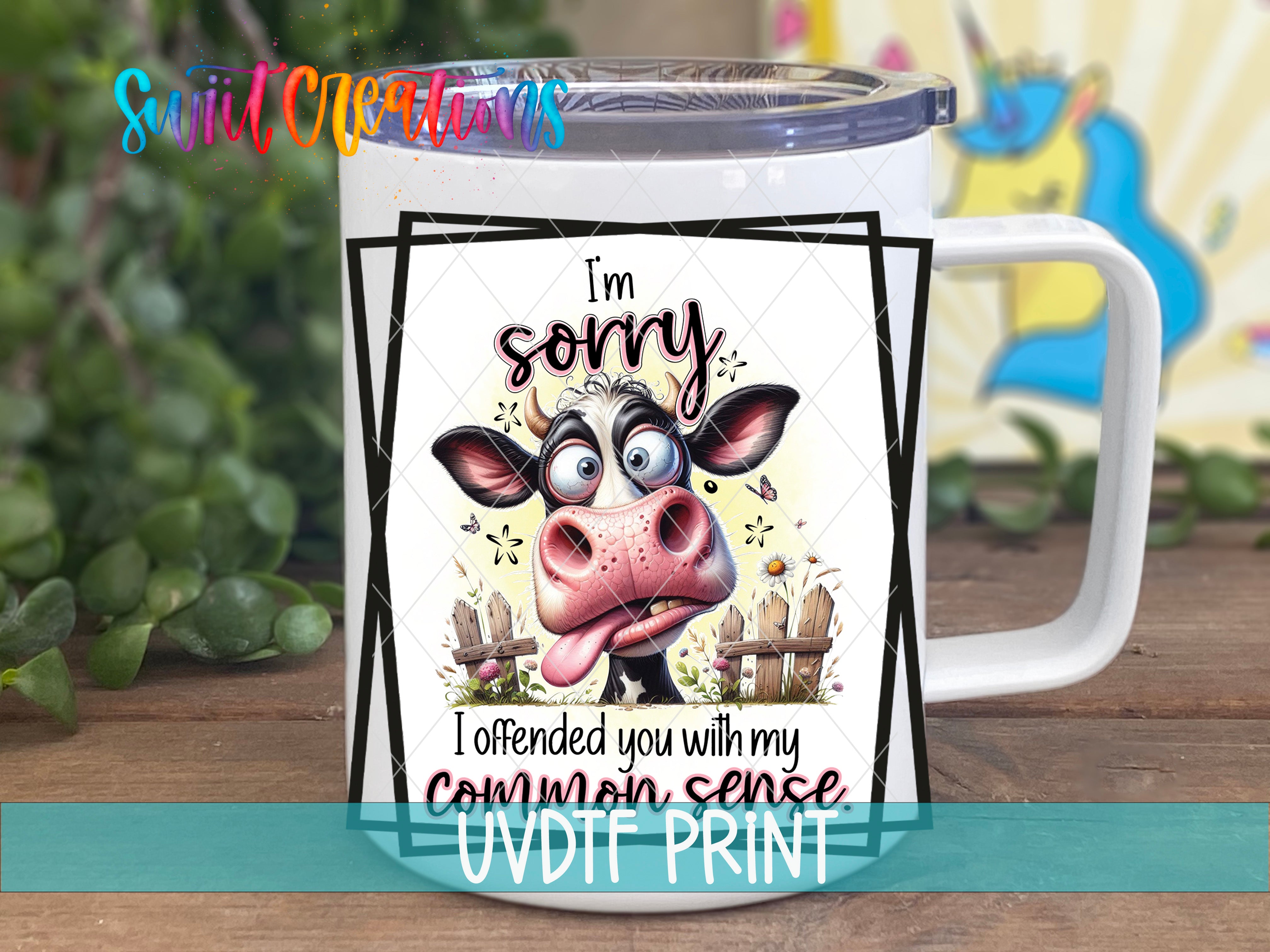 A white mug with a cartoon cow and text that says "I'm sorry I offended you with my common sense" printed on it.