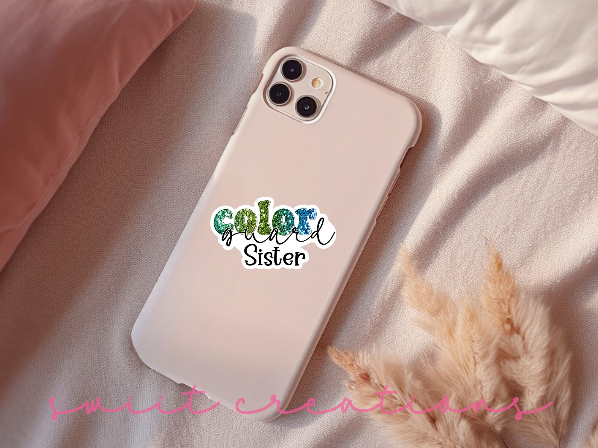 a phone case with a sticker on it sitting on a bed