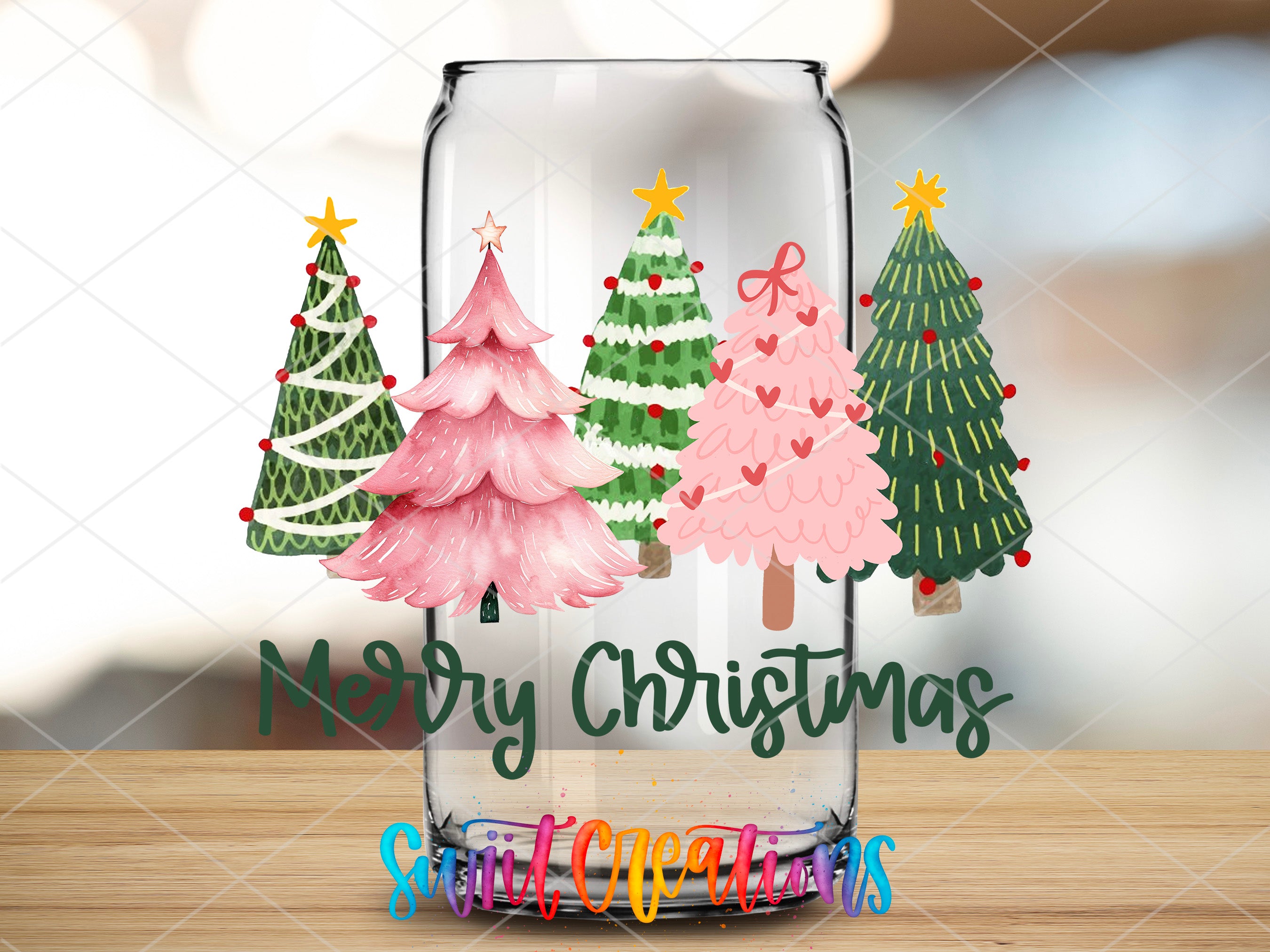 a glass jar filled with christmas trees on top of a wooden table