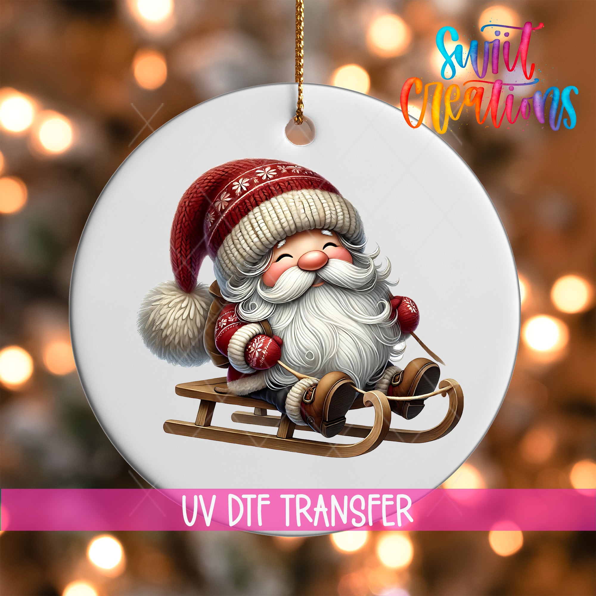 A white ornament featuring a smiling Santa Claus riding a sled, with a pink ribbon below the ornament.