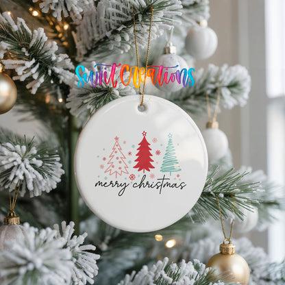 A white Christmas tree ornament with the text "merry christmas" is hanging from the tree, surrounded by other ornaments and lights.