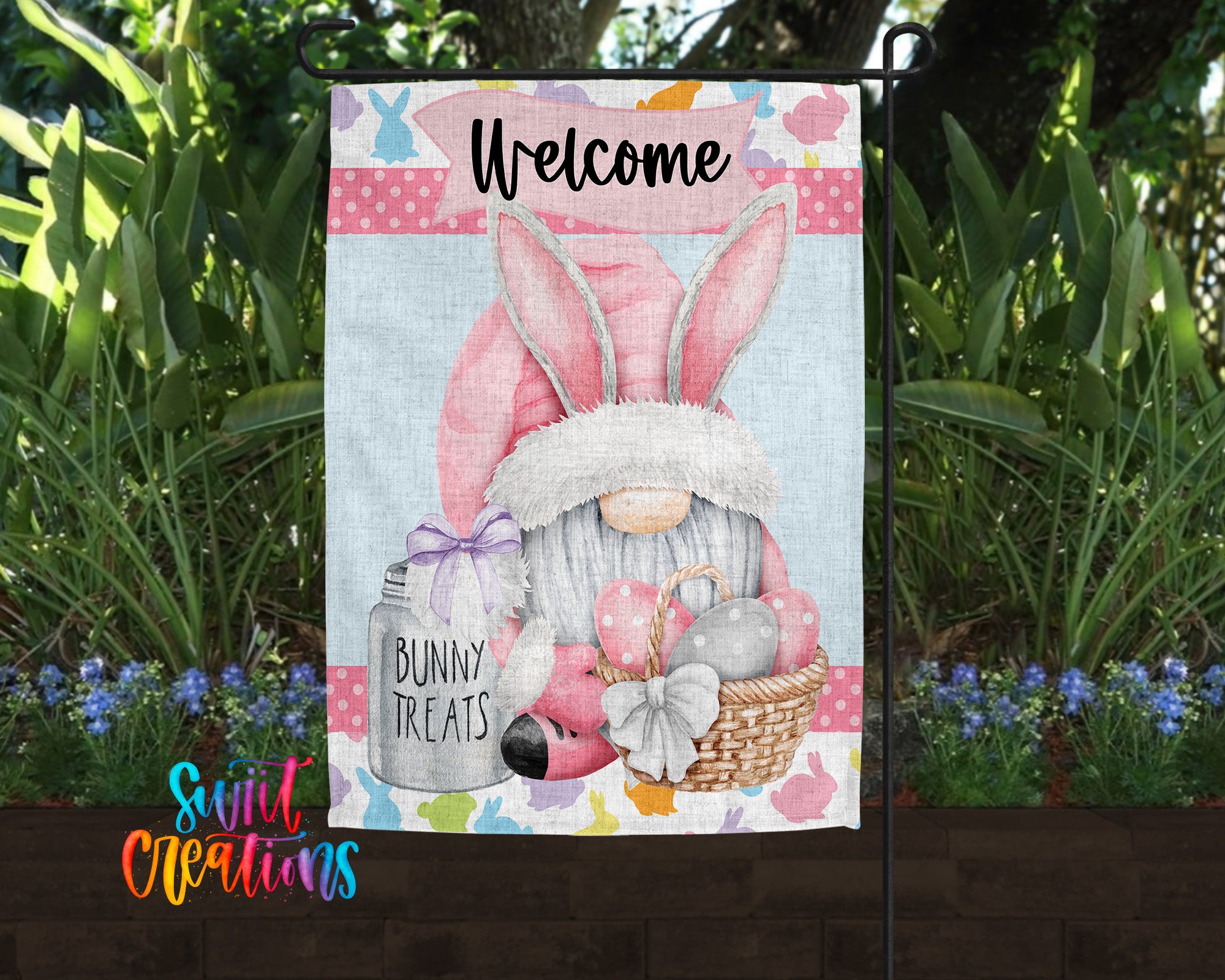 A colorful garden sign featuring a bunny gnome holding a jar of "Bunny Treats" and a basket of Easter eggs, surrounded by greenery and flowers.