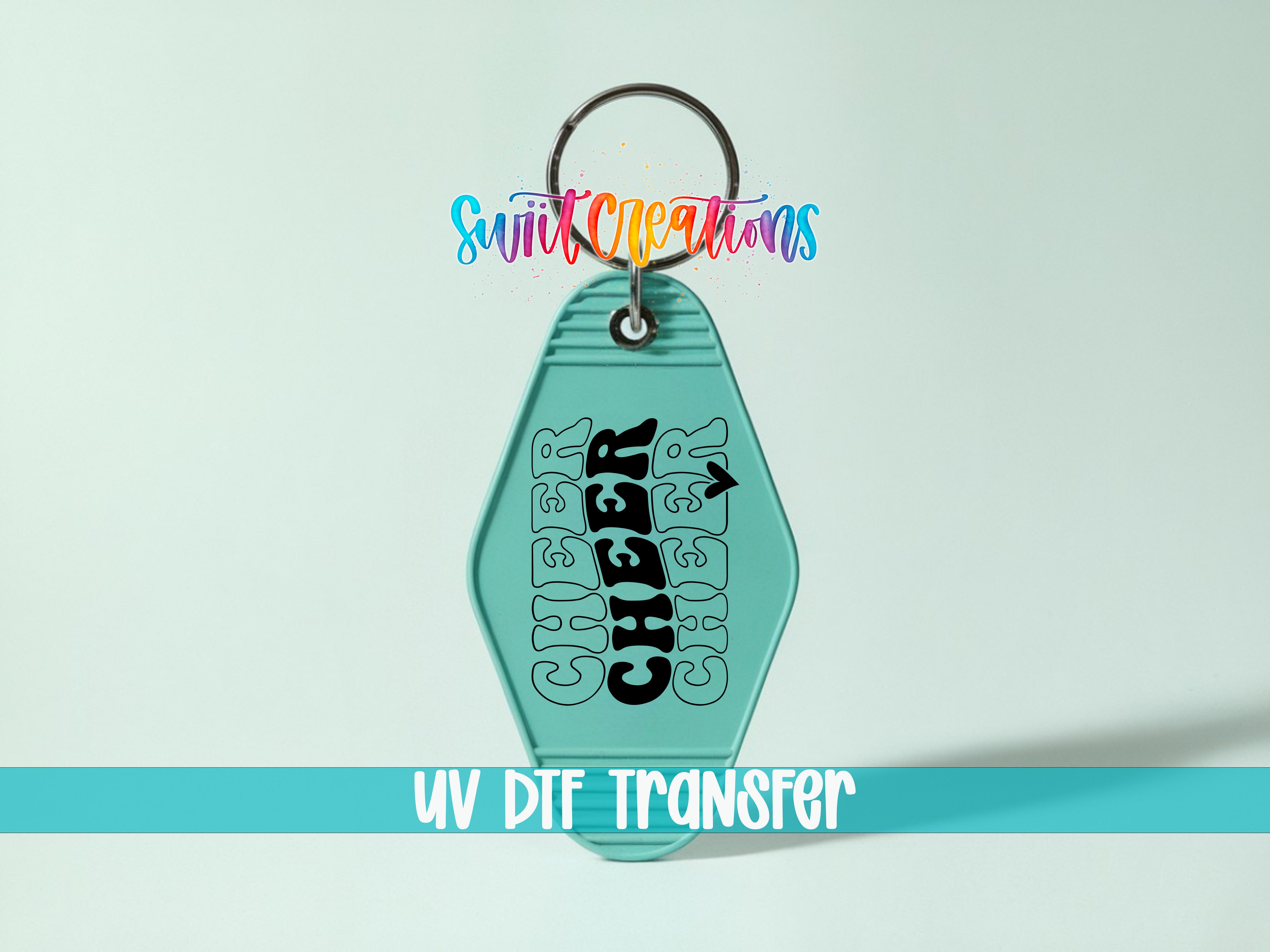 A keychain with the word "CHEER" printed on it, along with a colorful design. The keychain is attached to a keyring, and there is text at the bottom of the image that says "UV DIF TRANSFER".