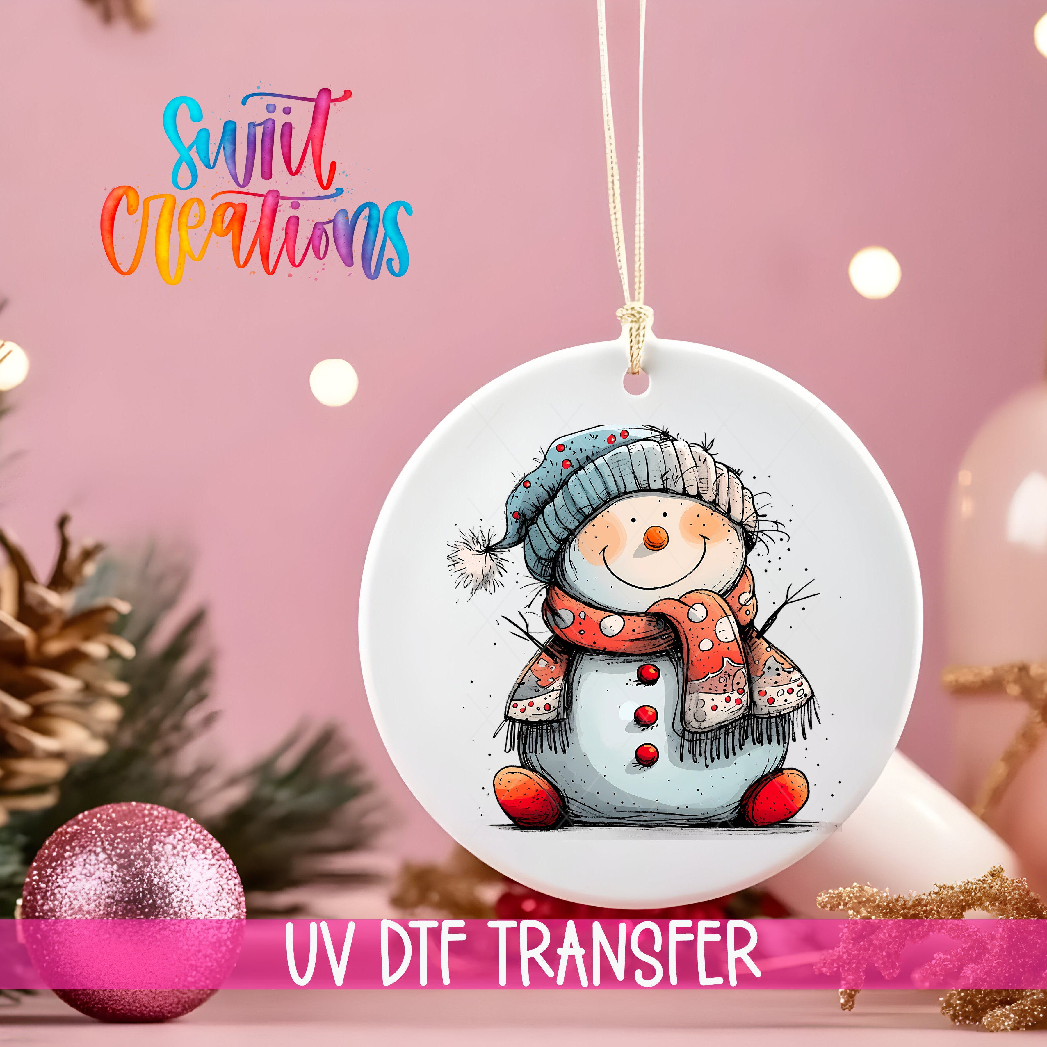 A white ceramic ornament with a snowman design hangs against a pink background, with a pink glitter ball and Christmas tree decorations visible in the background.