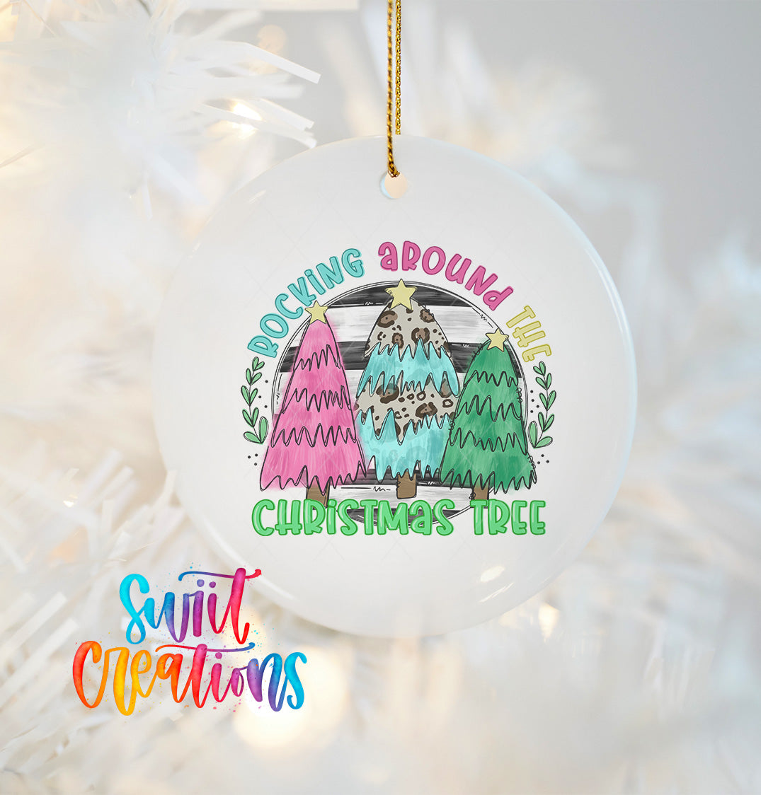 A white Christmas tree ornament with a colorful design featuring three stylized Christmas trees and the text "Rocking around this Christmas tree".
