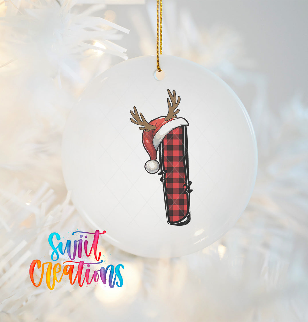 A white ornament with a red and black plaid pattern and a Santa hat with antlers is hanging on a Christmas tree.